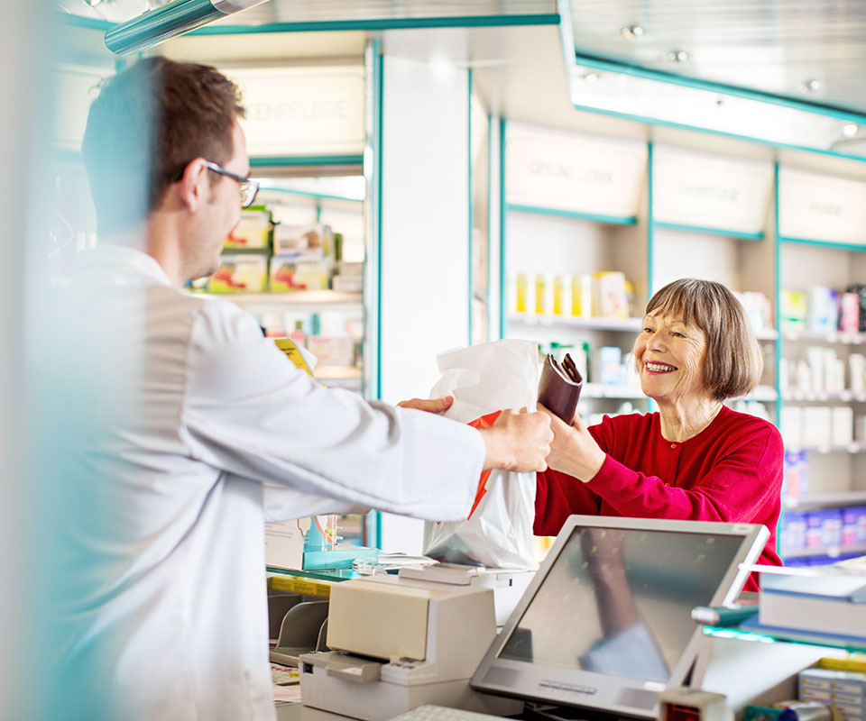 Senior woman picking up Rx, chatting with pharmacist