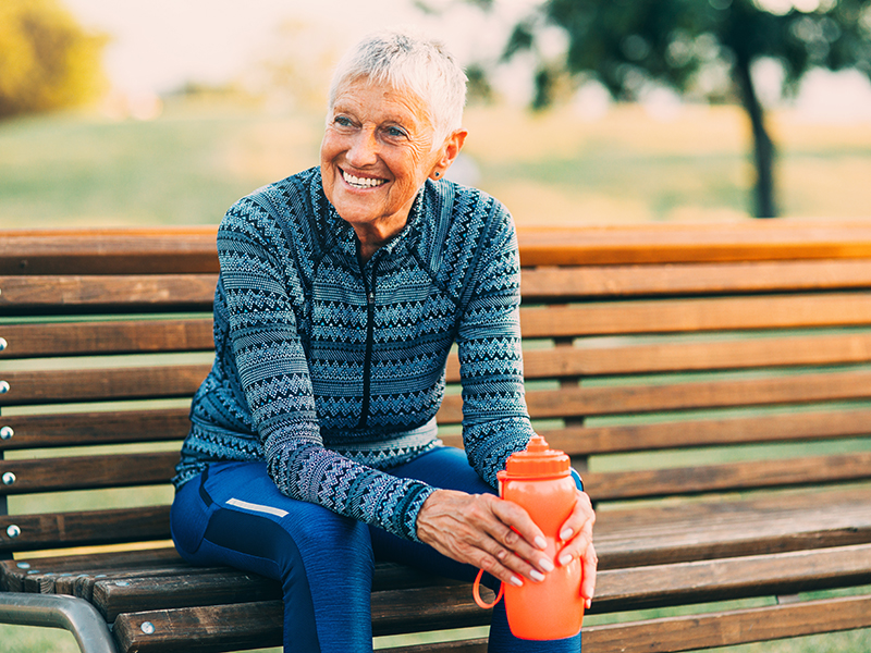 senior woman resting on bench outdoors.